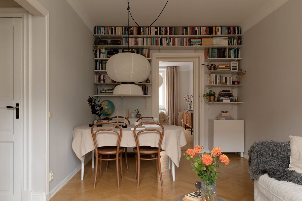 A Light Colored Swedish Apartment 6 living room with dining table and bookshelves
