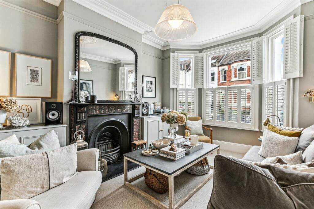 An Extended Victorian House Decorated in Gray Tones 1 living room with fireplace and light gray walls