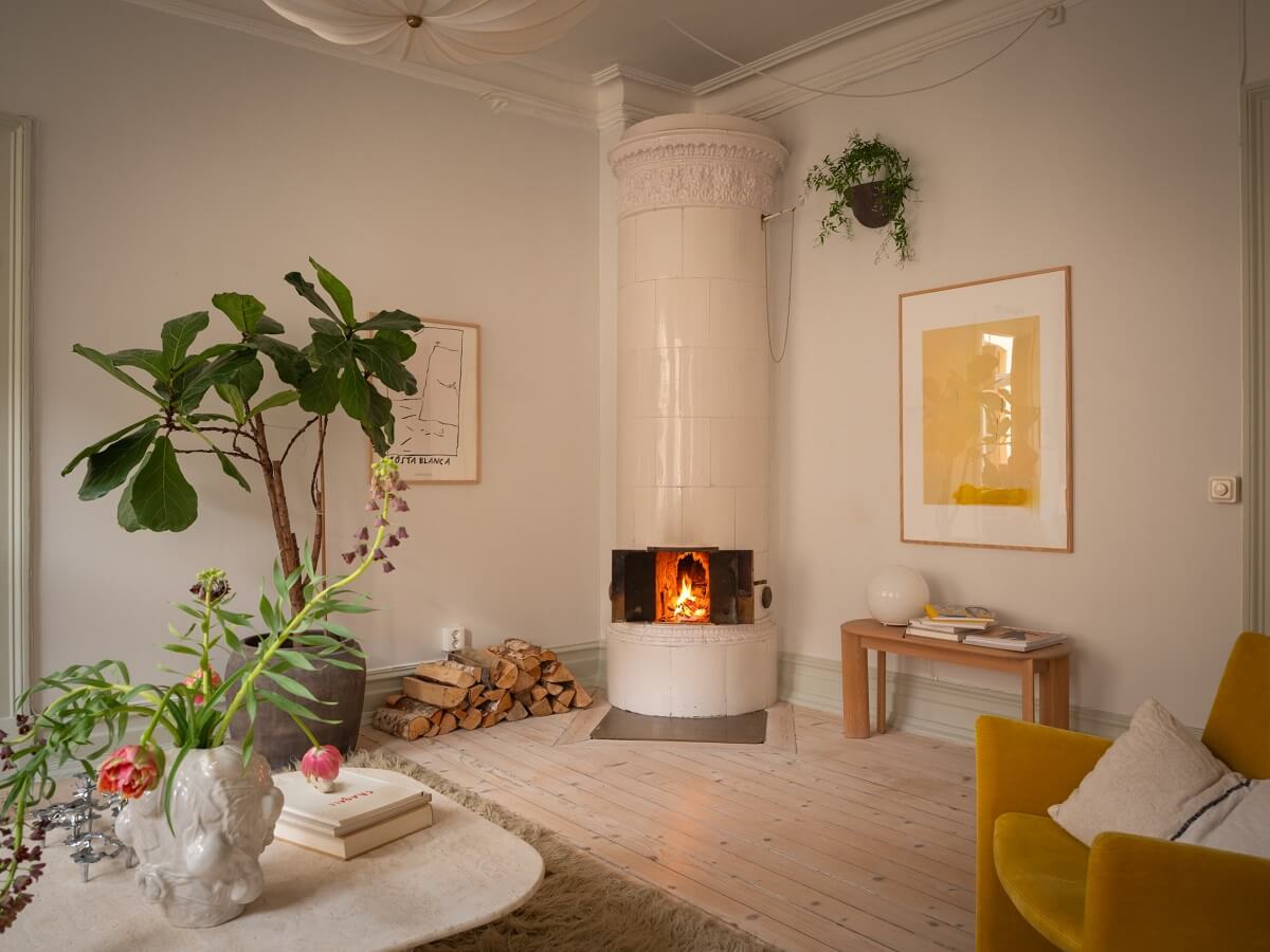 Light Rooms and Soft Color Tones in a Swedish Apartment 6 living room with ochre yellow chair and round fireplace