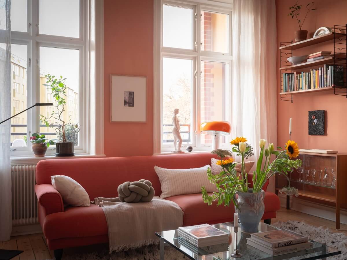 A Scandinavian Apartment with a Warm Living Room and Rounded Walls 6 living room with pink sofa and terracotta wall color