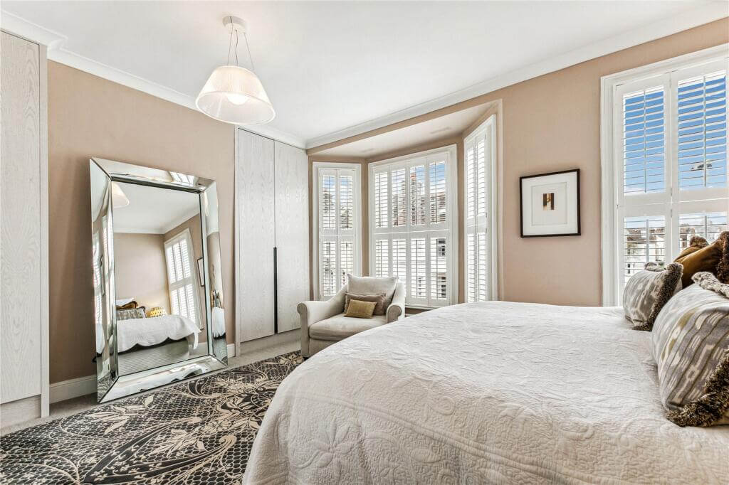 An Extended Victorian House Decorated in Gray Tones 10 master bedroom with beige pink walls