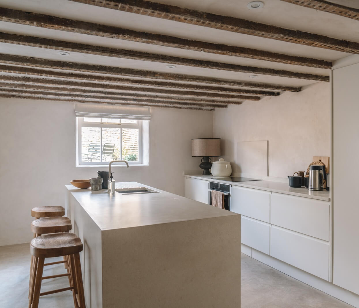 Contemporary Interiors in a Historic English House 11 modern white kitchen with island and exposed ceiling beams