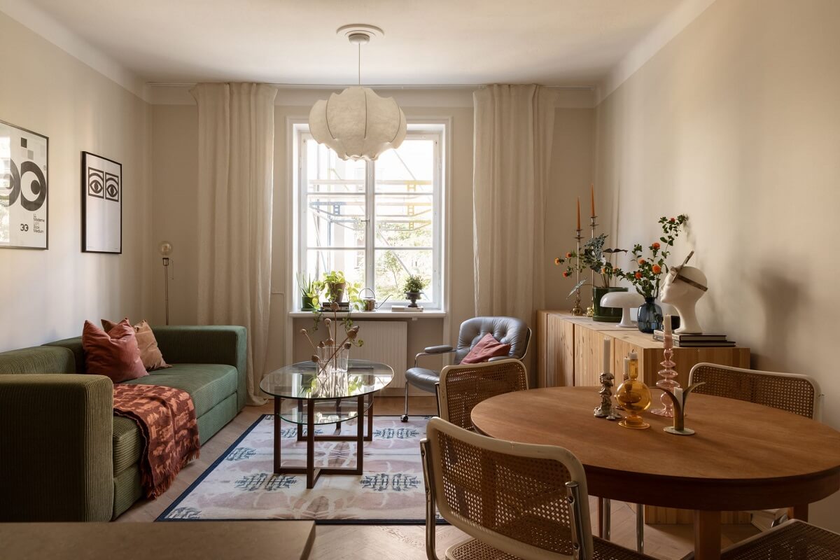 A Renovated Swedish Apartment with a Pink Bathroom 1 open plan living room with green sofa and round table