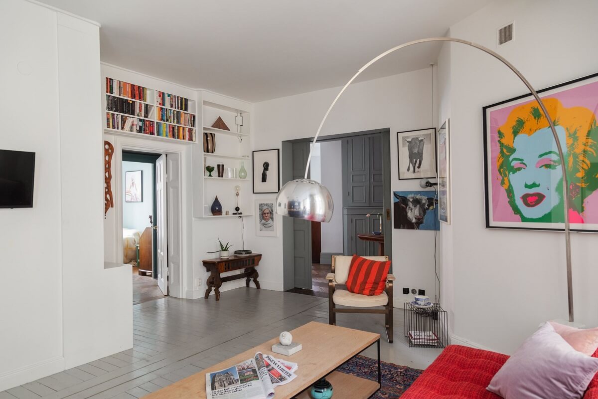 Moody Rooms in a Grand Stockholm Apartment 16 open plan sitting room kitchen with bookshelves above doorframe