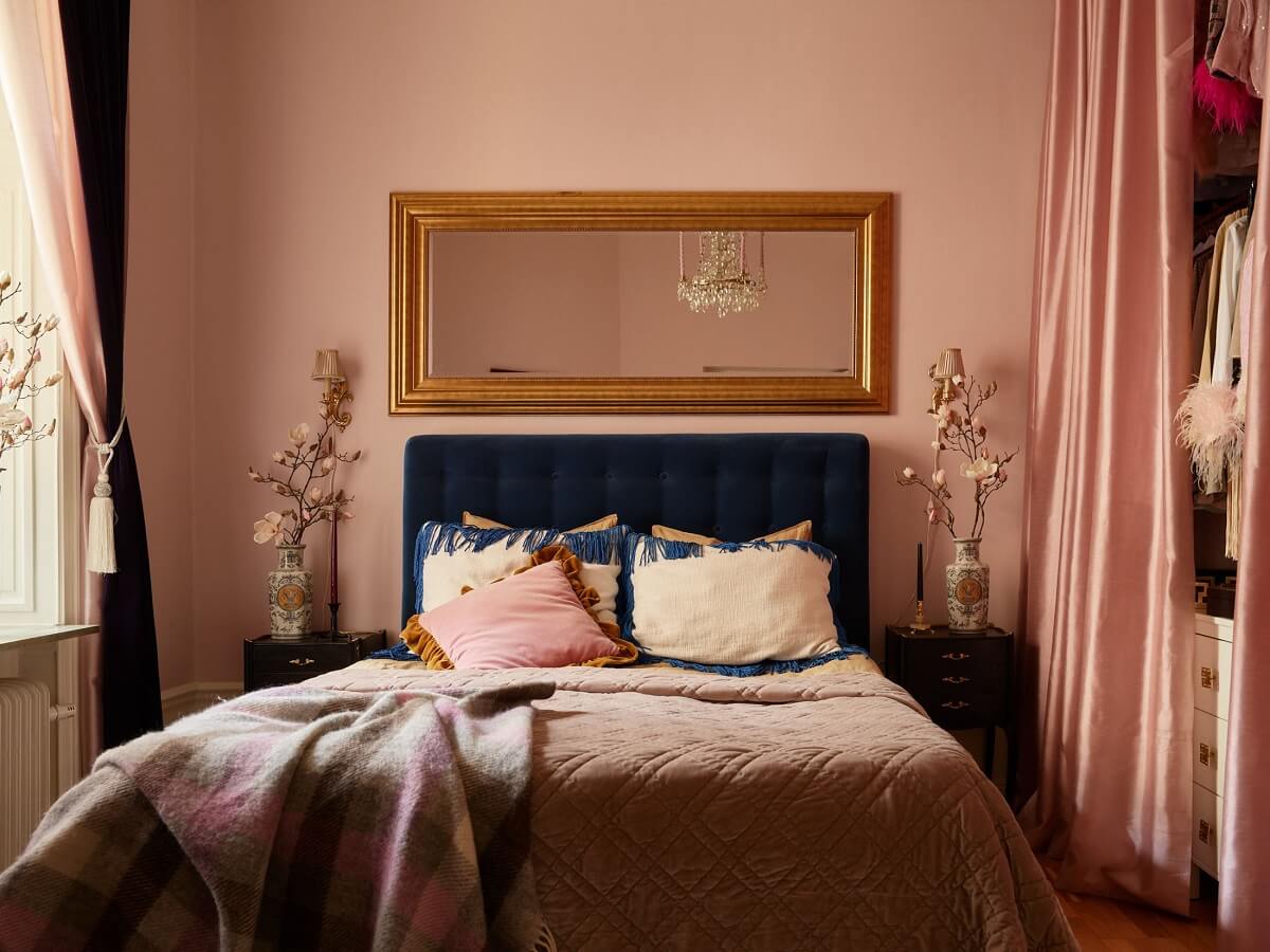 A Classic & Cozy Apartment Painted in Pastel Pink and Blue 10 pastel-pink-bedroom-with-blue-velvet-bedframe-wardrobes-hidden-by-curtain-nordroom