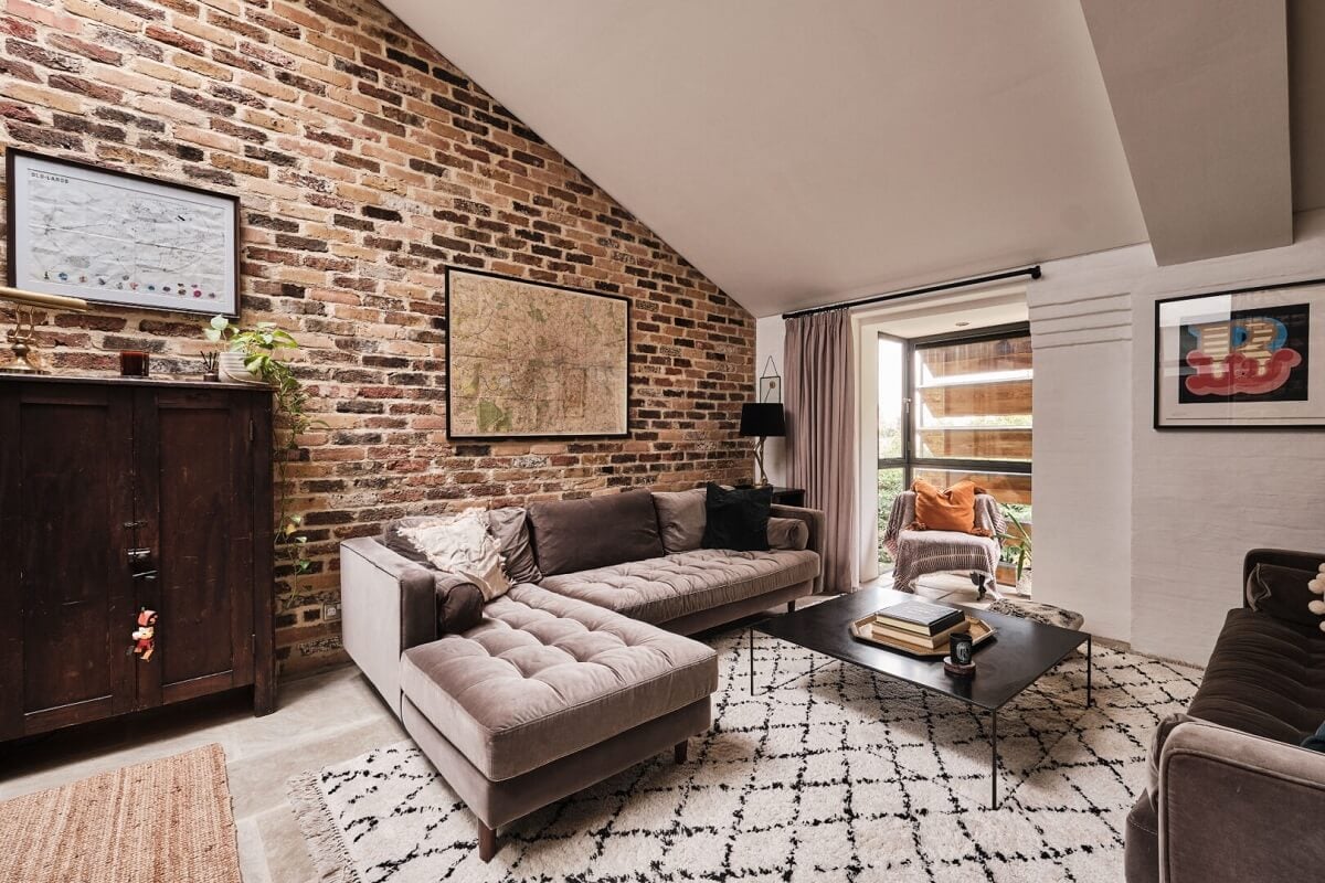 A London Warehouse Conversion with a Black deVOL Kitchen 3 pitched ceiling and brick walls in living room