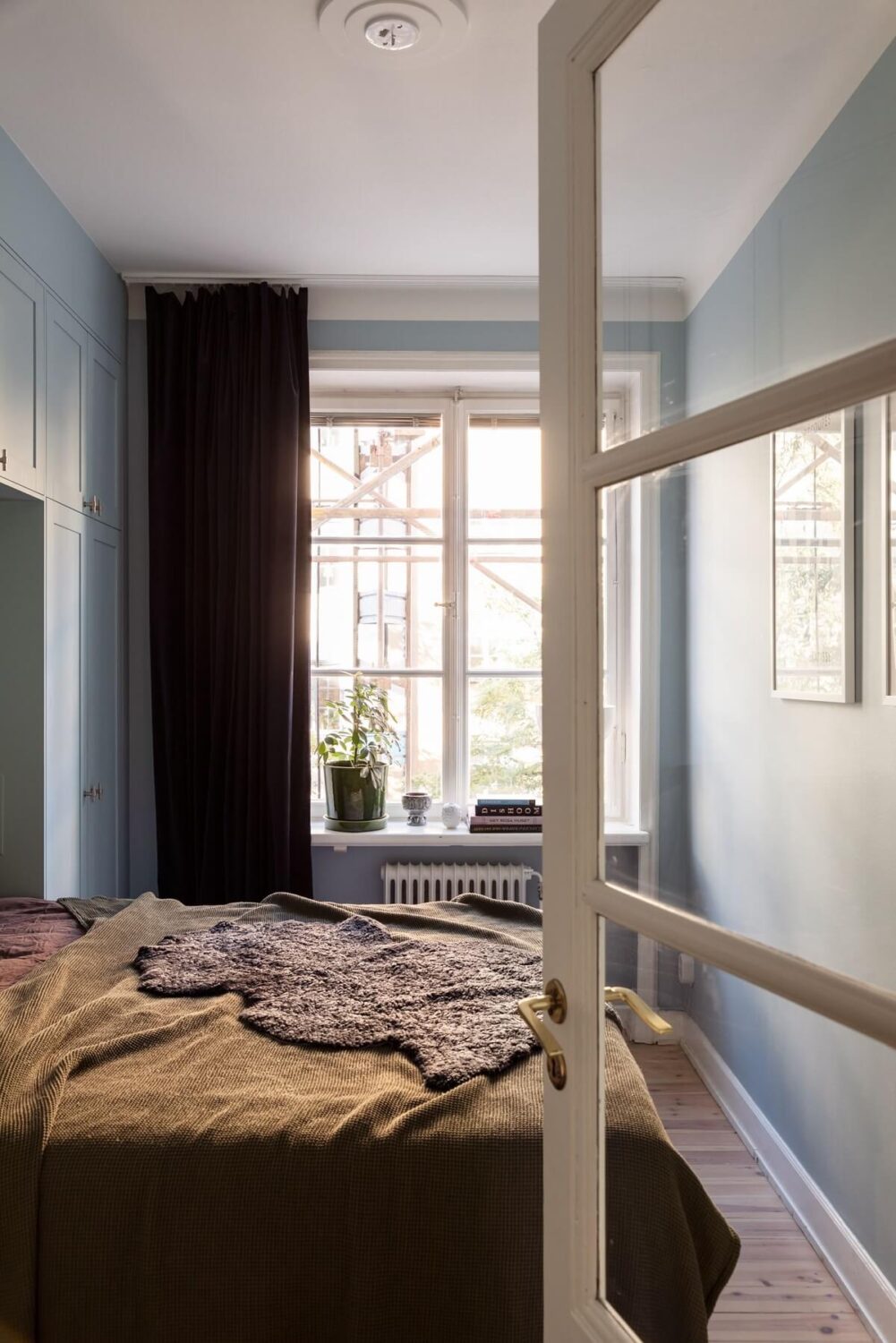 A Renovated Swedish Apartment with a Pink Bathroom 11 small bedroom with blue walls and custom wardrobes