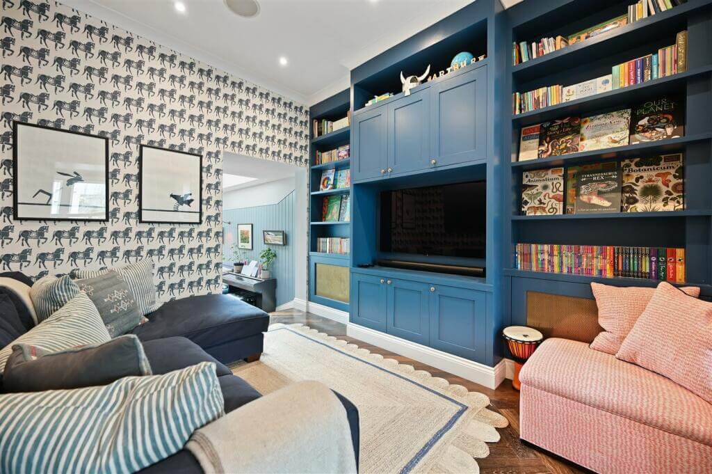 A London Family Home with Blue Color Accents 4 television room with blue feature wall with bookshelves