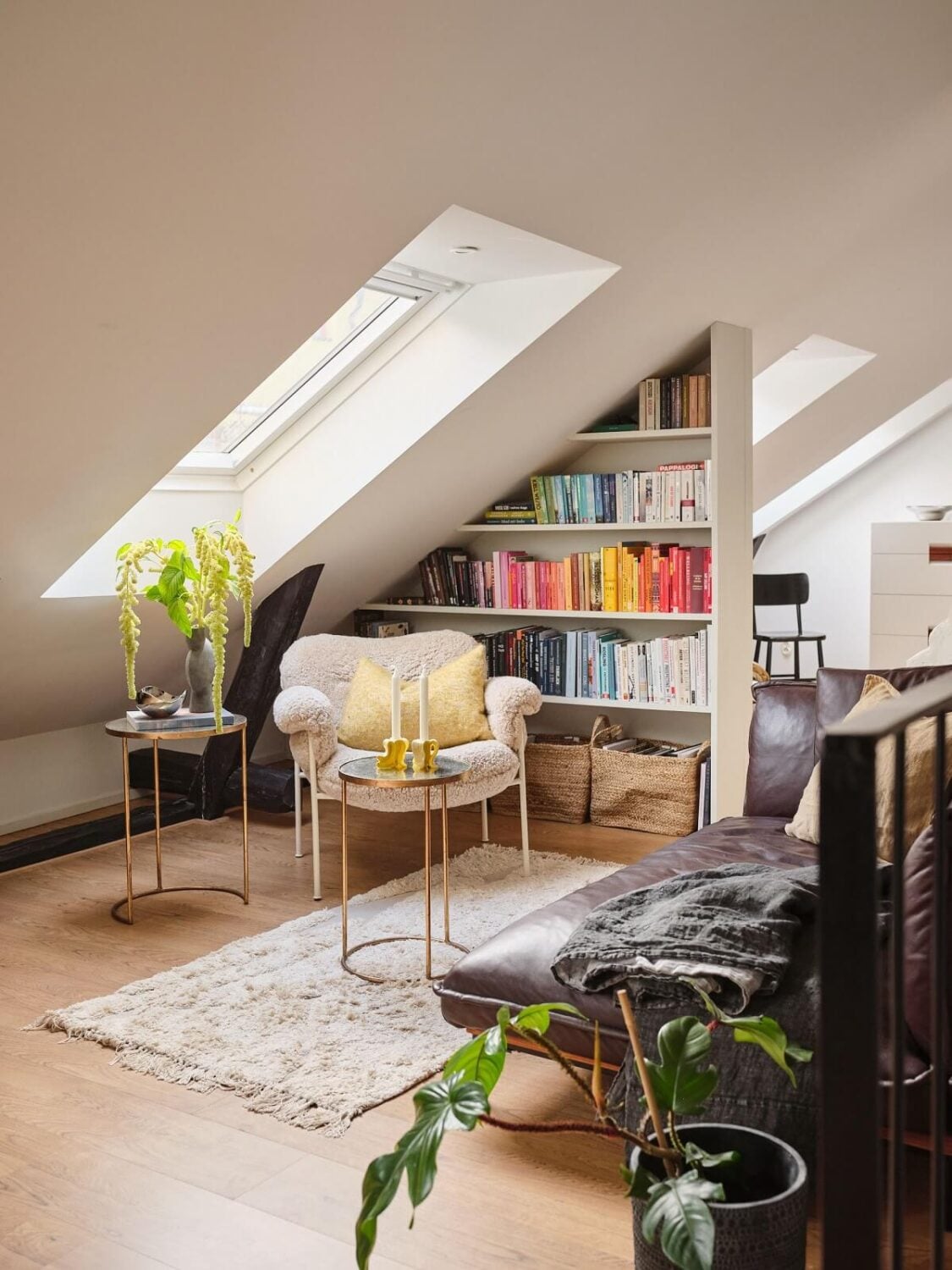A Light Filled Duplex Apartment in Sweden 17 top floor sitting room with bookshelves under slanted ceiling