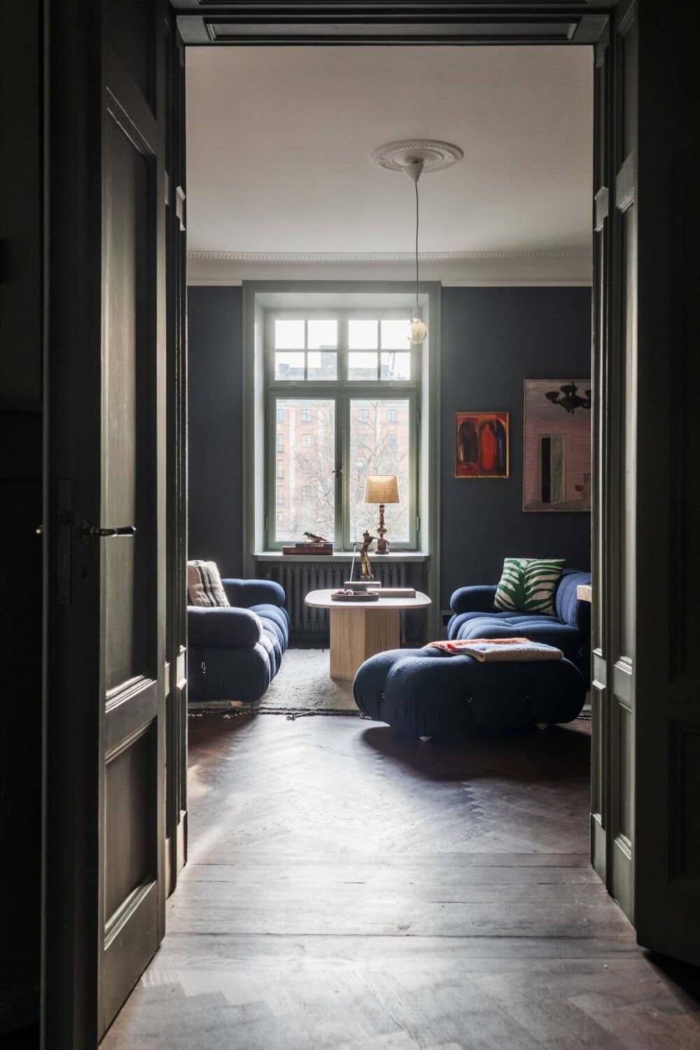 Moody Rooms in a Grand Stockholm Apartment 2 view into moody sitting room with blue walls