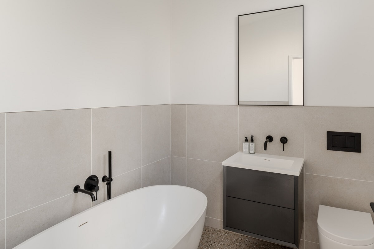 A Scandinavian-Inspired Cabin in the Woods 13 white and gray modern bathroom with bath