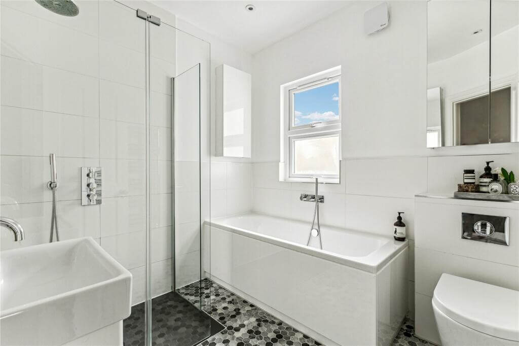 An Extended Victorian House Decorated in Gray Tones 11 white bathroom with gray floor tiles