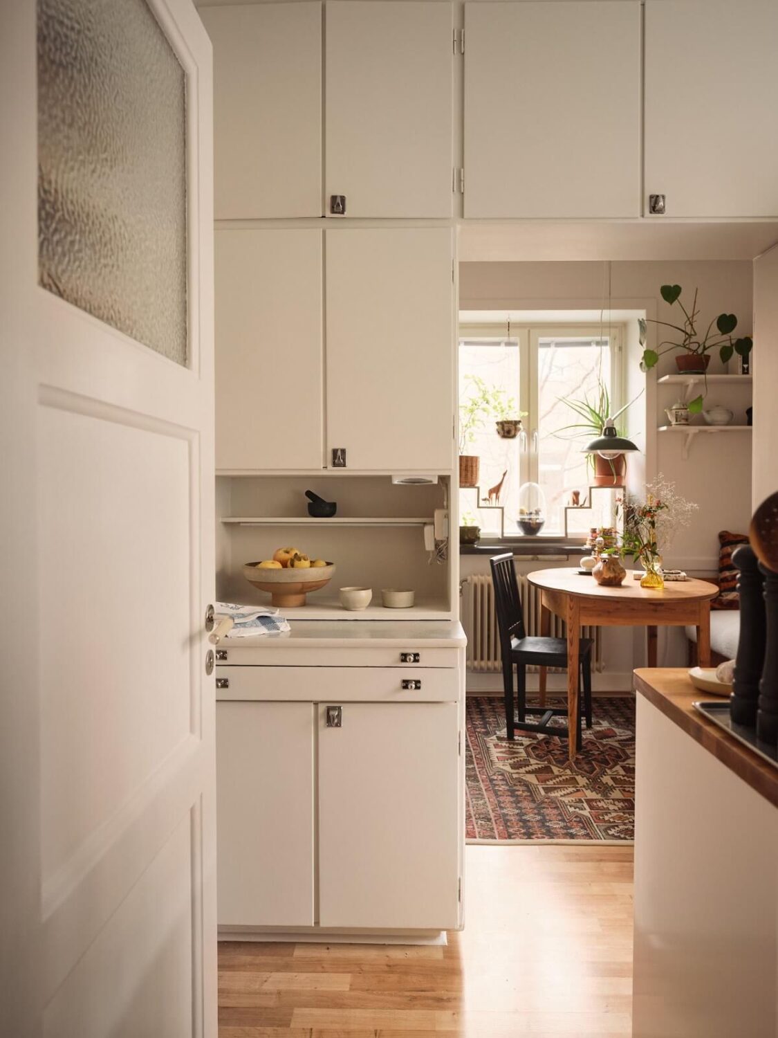 A Small Apartment with a Cozy Dining Nook 12 white built in cabinets