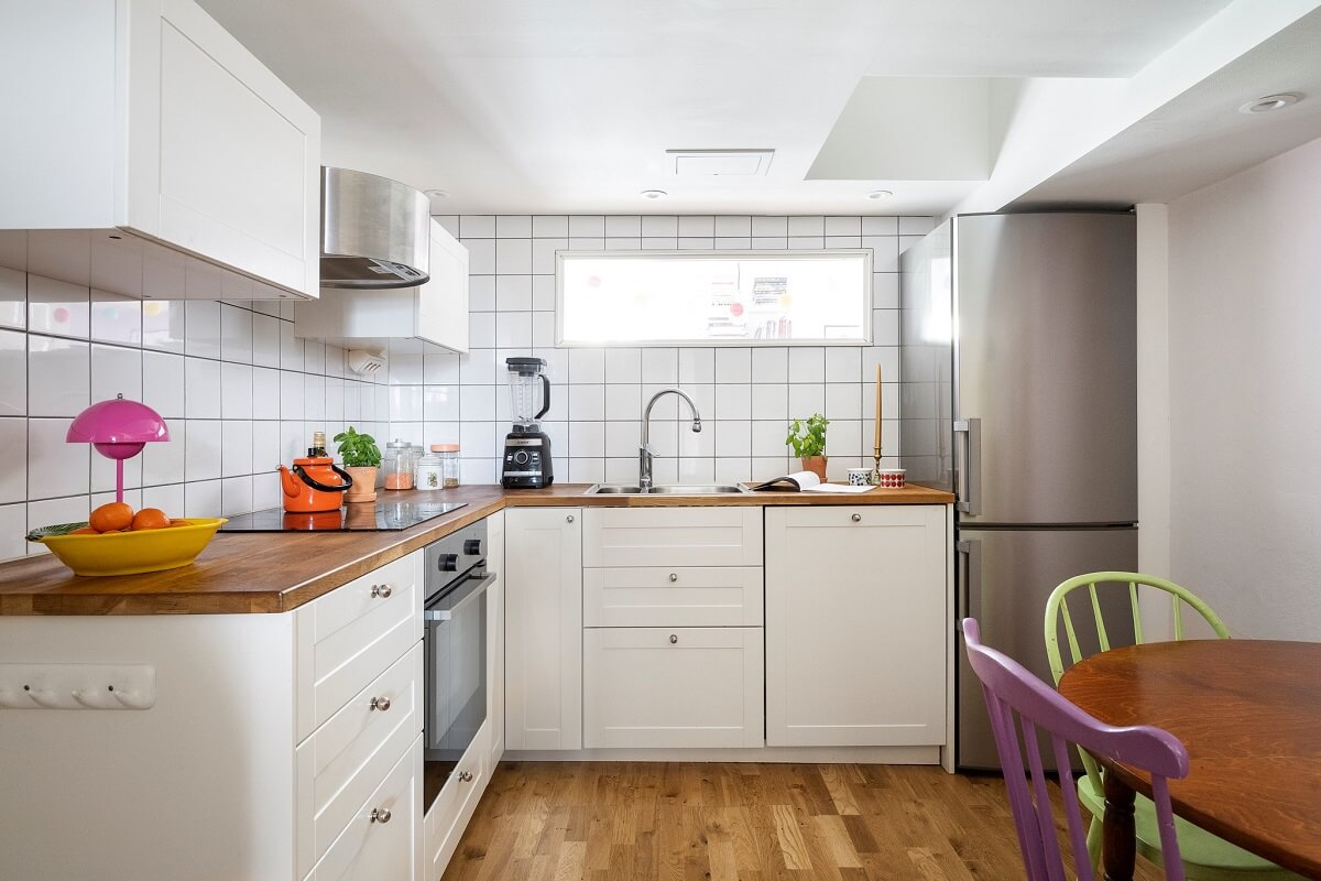 A Basement Family Apartment with Colorful Furniture and Decor 9 white kitchen with round table