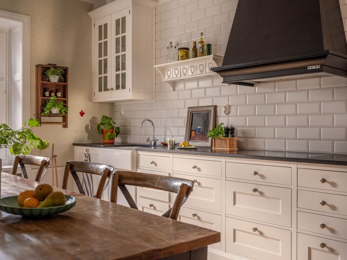 A Classic Swedish Apartment Decorated in Green and Pink Tones 16 wooden dining table and cream colored kitchen cabinets
