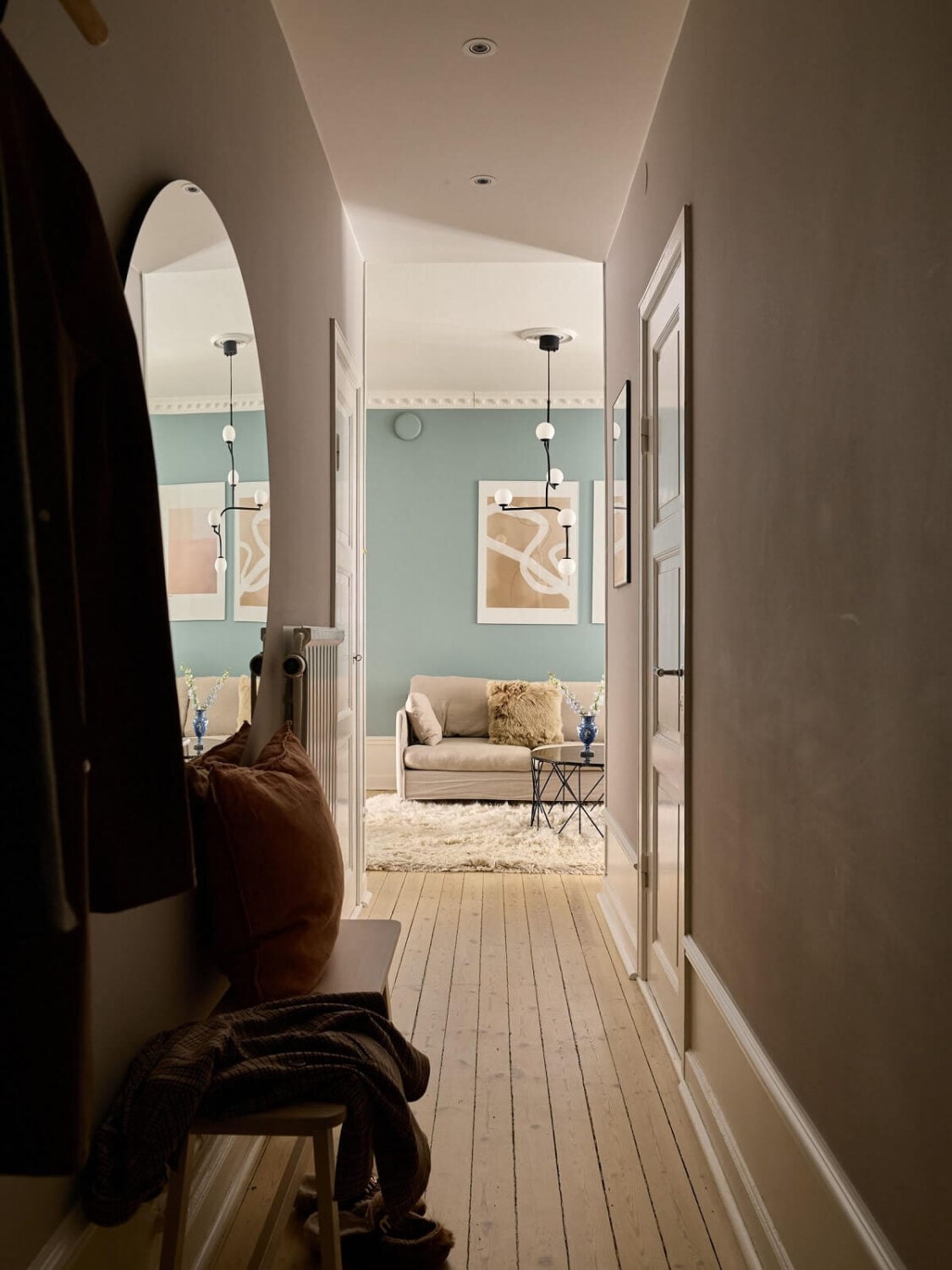 A Social Scandinavian Apartment with a Light Blue Living Room 18 wooden floor and large round mirror hallway