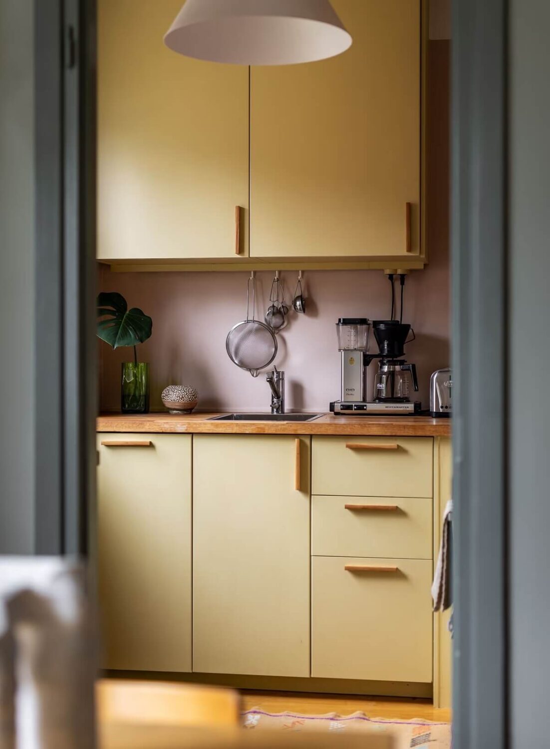 A Cozy Studio Apartment with a Yellow Kitchen 12 yellow kitchen cabinets