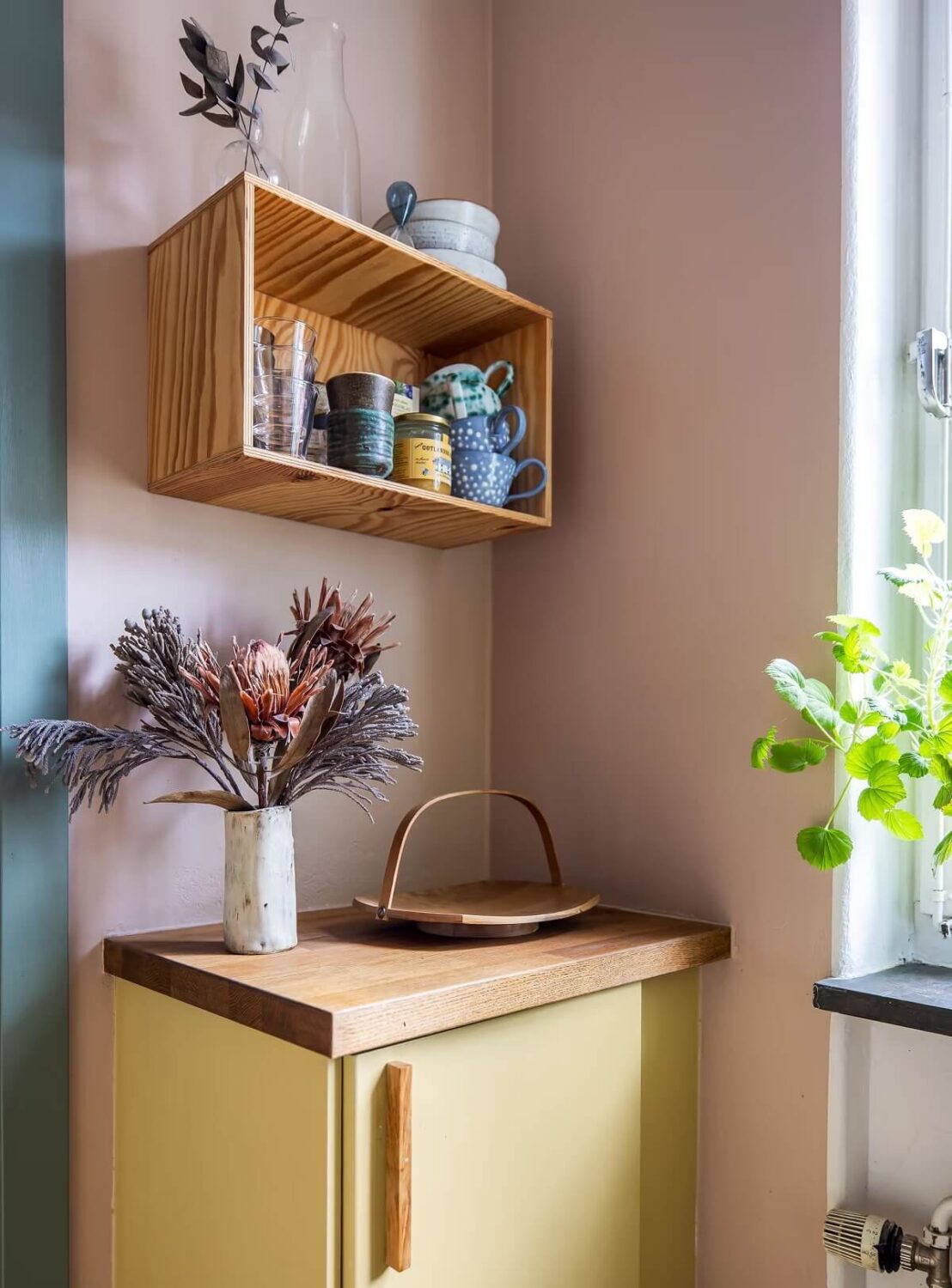 A Cozy Studio Apartment with a Yellow Kitchen 16 yellow kitchen cabinets and pink walls