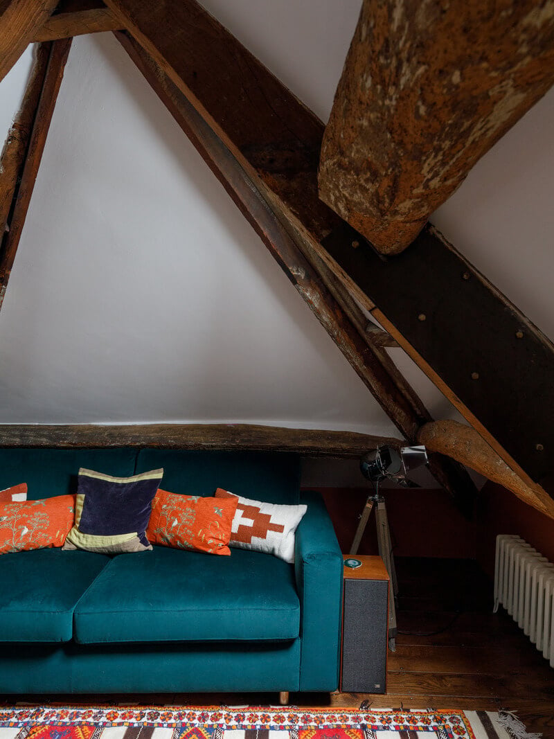 A Charming English Cottage Filled with Historic Character 21 attic bedroom with emerald sofa
