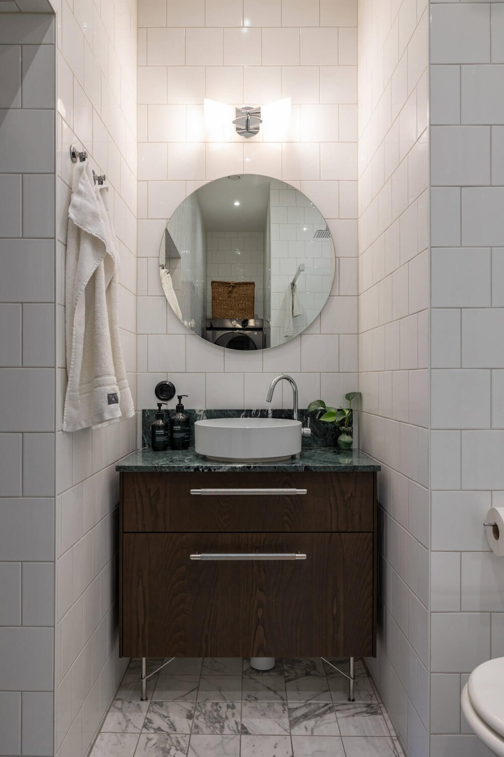 A Classic Swedish Apartment with a Dark Blue Bedroom 17 bathroom with marble tiles and round mirror
