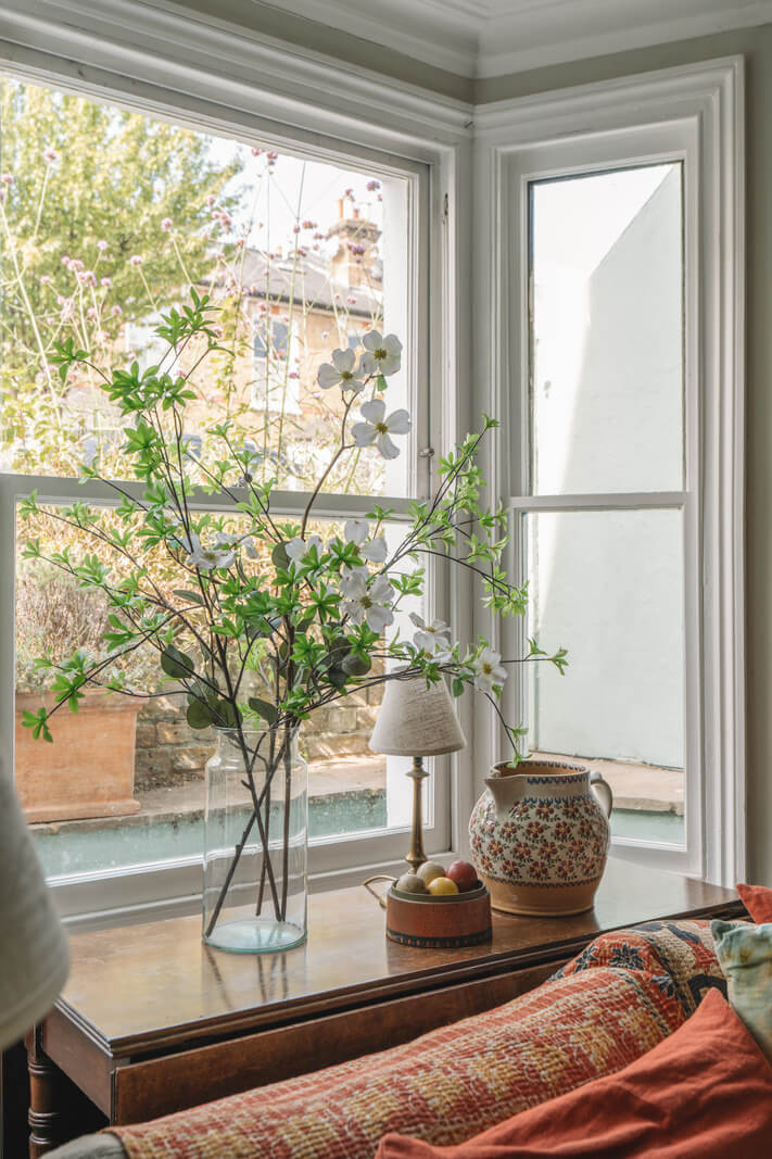 A Warm Muted Color Palette in a Victorian House 24 bay window table behind sofa