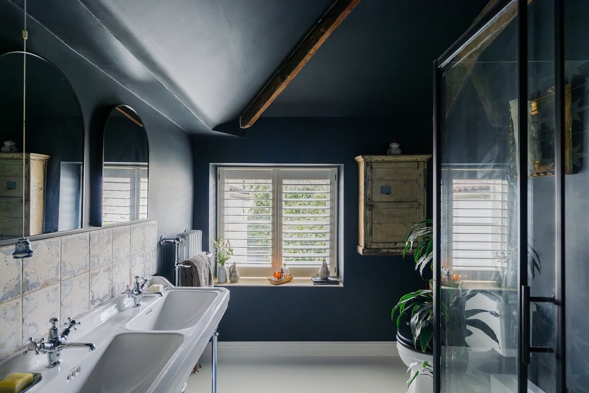 A Charming English Cottage Filled with Historic Character 15 blue bathroom with double sink and wooden beam