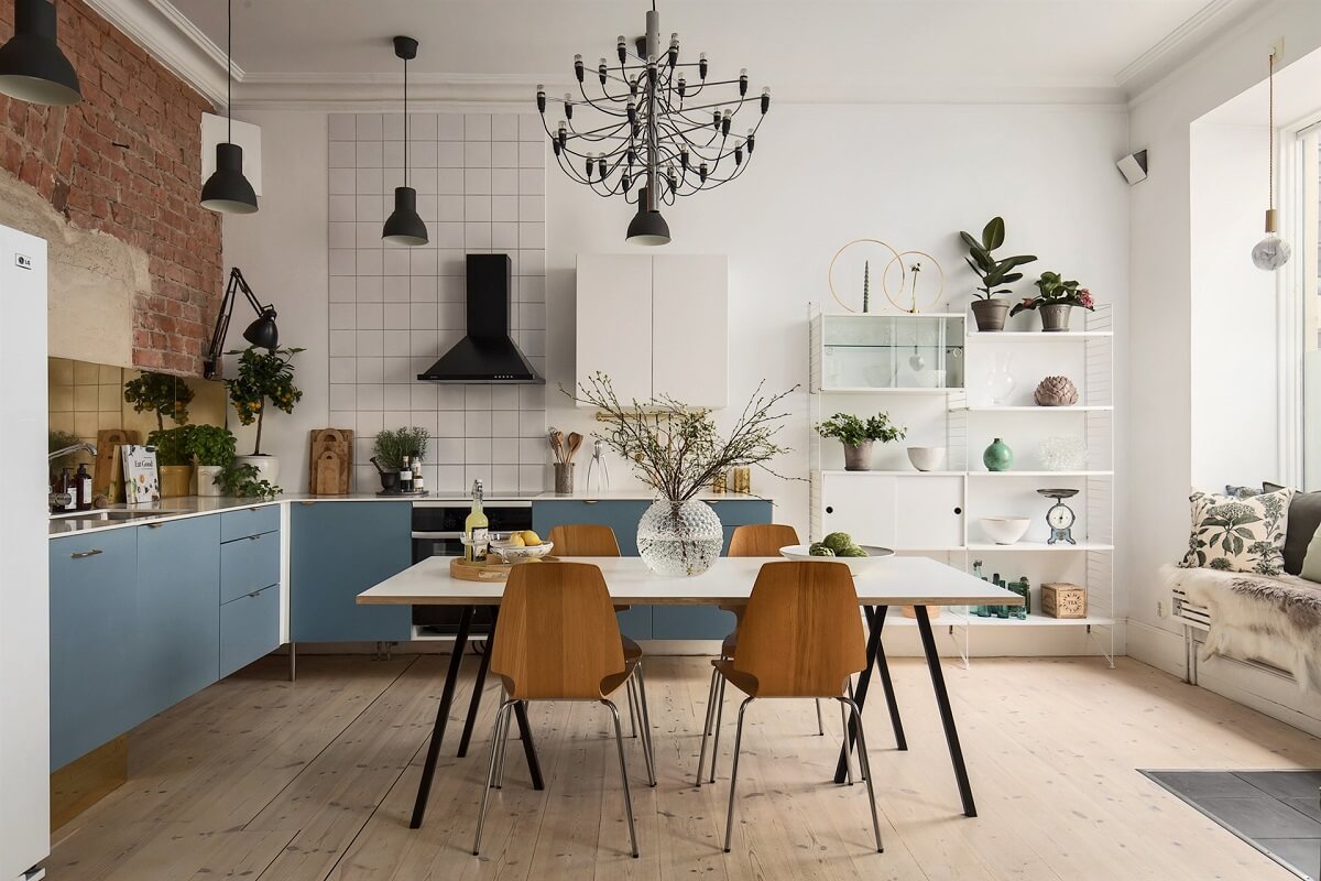 A Swedish Apartment with an Exposed Brick Wall 2 blue kitchen cabinets and brick wall