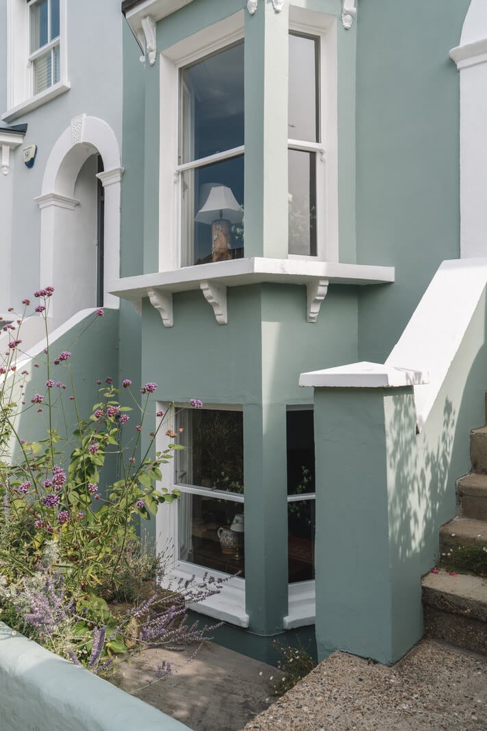 A Warm Muted Color Palette in a Victorian House 41 blue painted facade with bay window