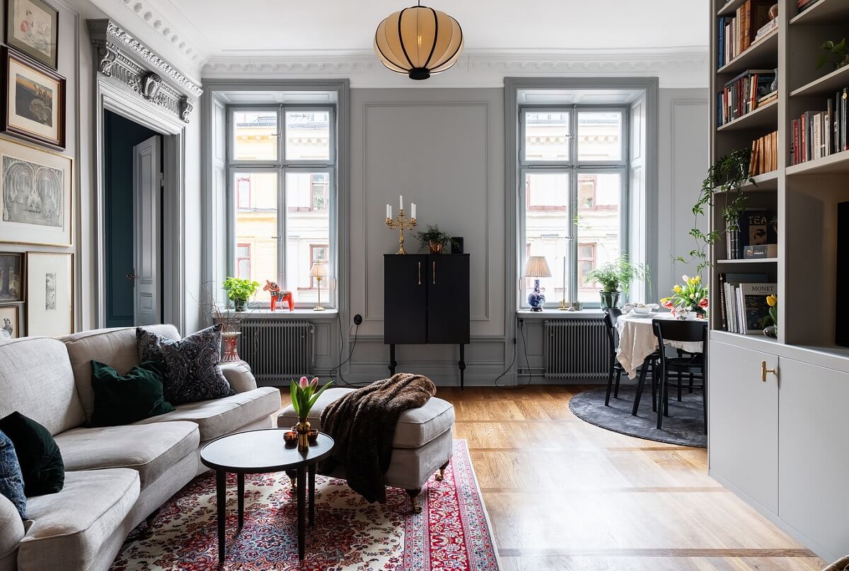 A Classic Swedish Apartment with a Dark Blue Bedroom 2 classic light gray living room with art and built in bookcases