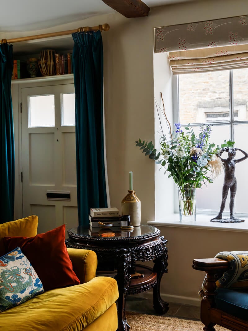 A Charming English Cottage Filled with Historic Character 2 cottage living room with ochre yellow sofa and front door with curtains