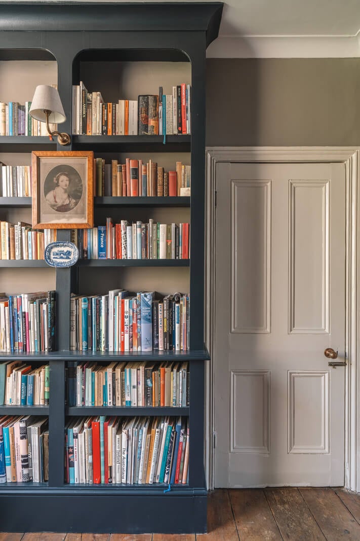 A Warm Muted Color Palette in a Victorian House 11 dark blue bookcase