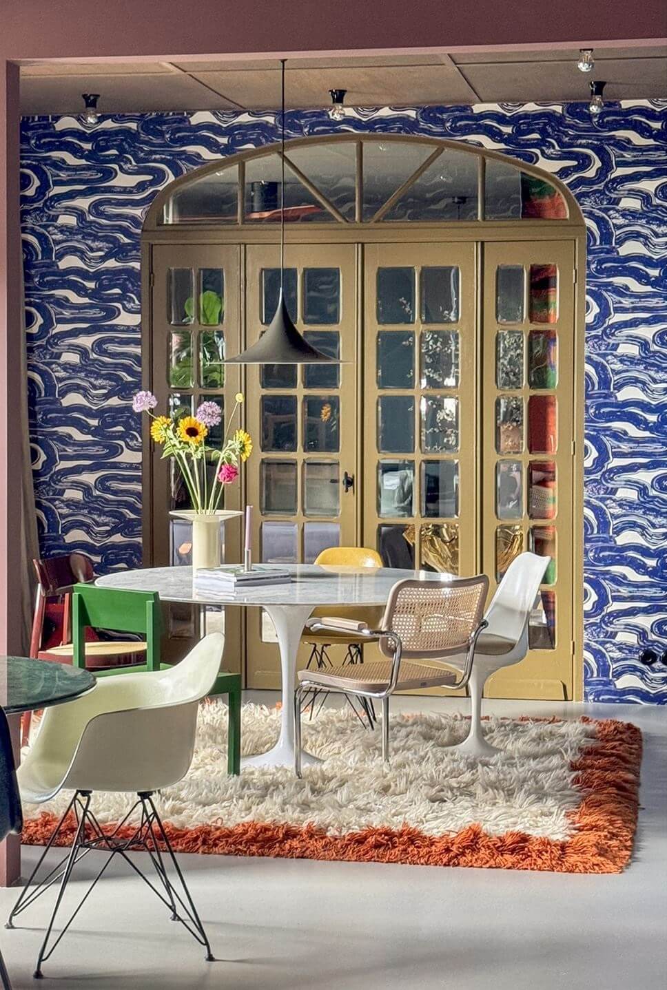 Color and Graphic Design in the Home of a Dutch Interior Stylist 21 dining room with large rug and graphic blue wallpaper