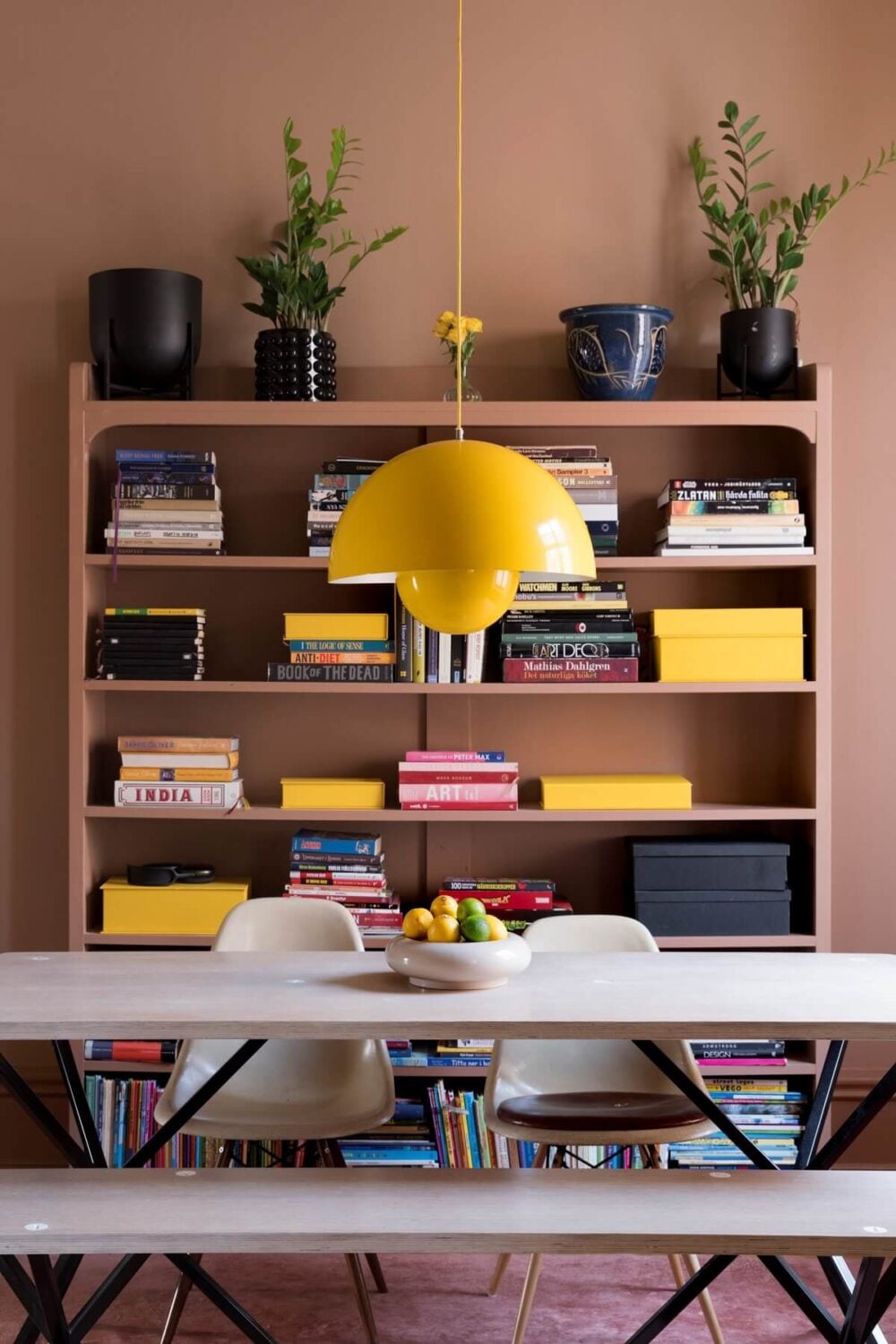 A Pink Apartment with a Black Kitchen 7 dining table with bench and yellow flowerpot pendant nordroom