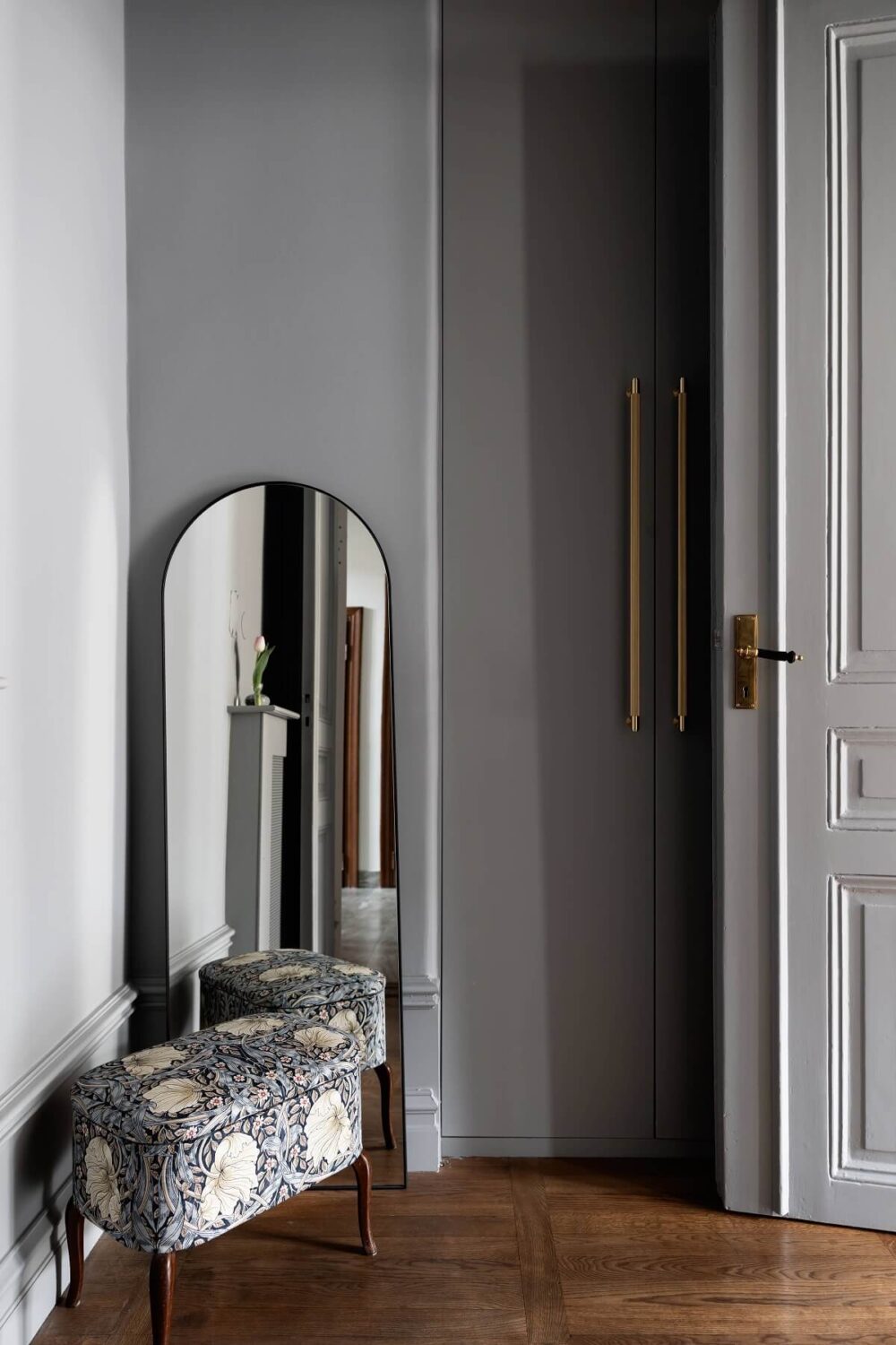 A Classic Swedish Apartment with a Dark Blue Bedroom 19 gray hallway with rounded mirror and built in wardrobe
