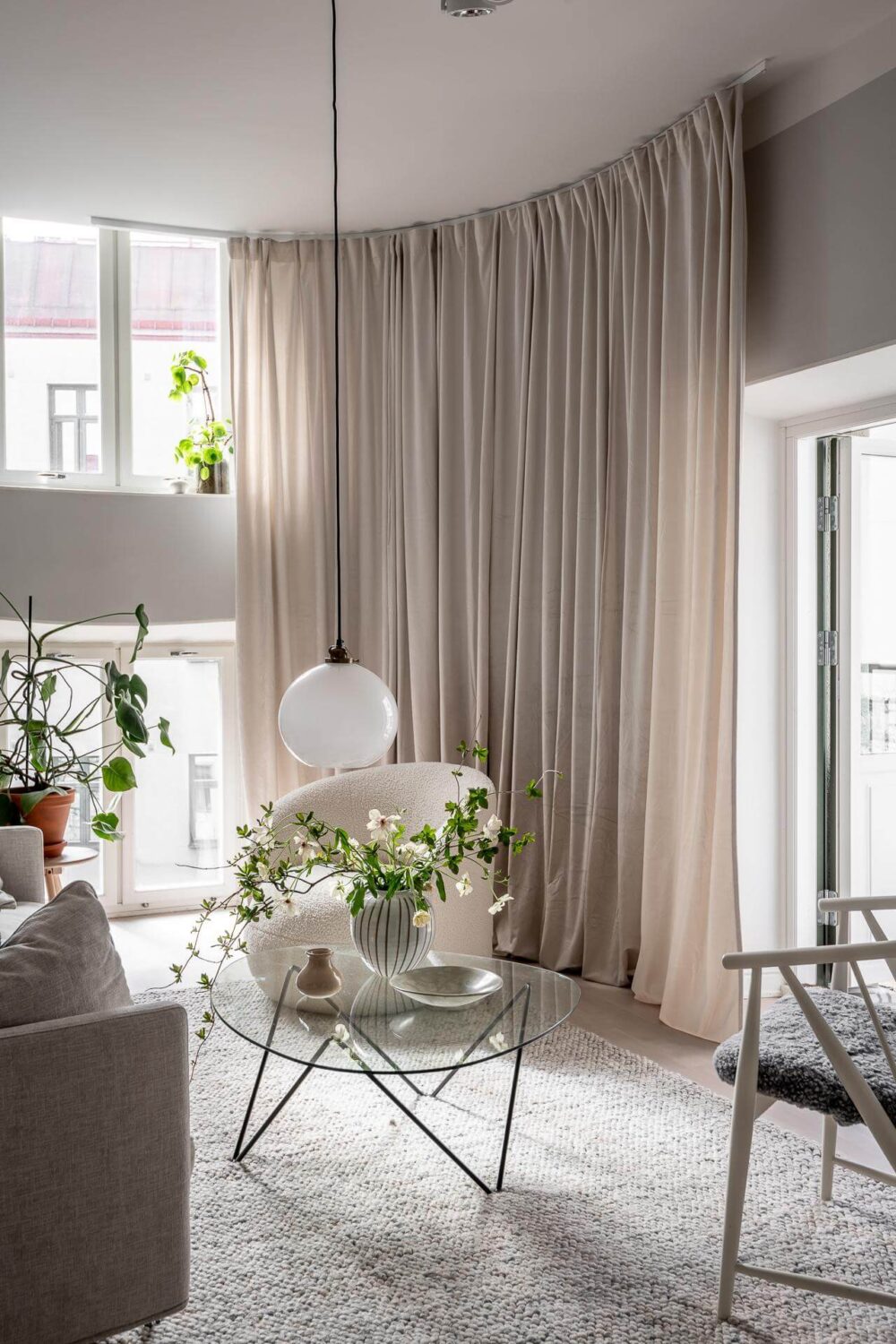 A Stylish Light Gray Swedish Apartment 2 gray scandinavian living room with floor to ceiling curtains