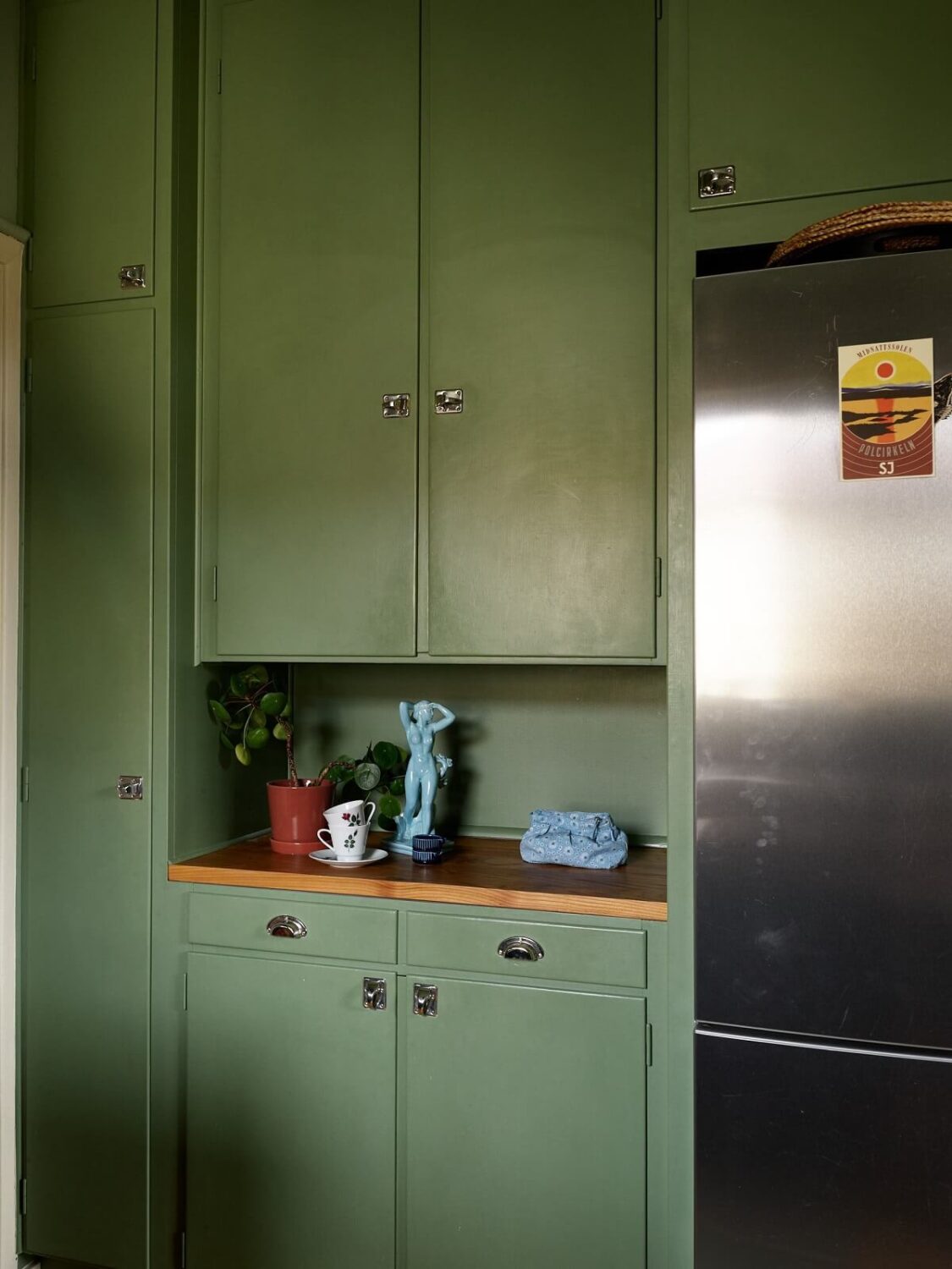 Revisiting a Small Green and Pink Midcentury Apartment 5 green built in cabinets in kitchen