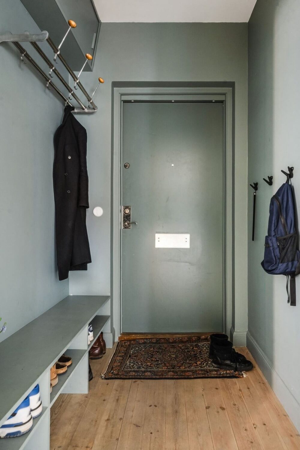 A Swedish Family Apartment with a Butter Yellow Kitchen 21 green hallway A Swedish Family Apartment with a Butter Yellow Kitchen