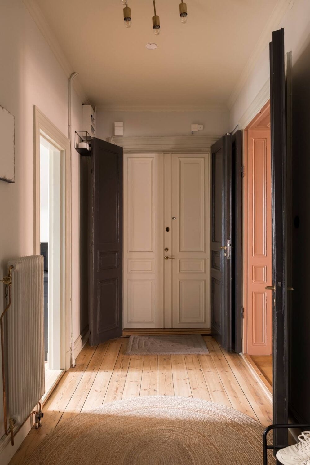 A Pink Apartment with a Black Kitchen 19 hallway with dark gray wooden doors
