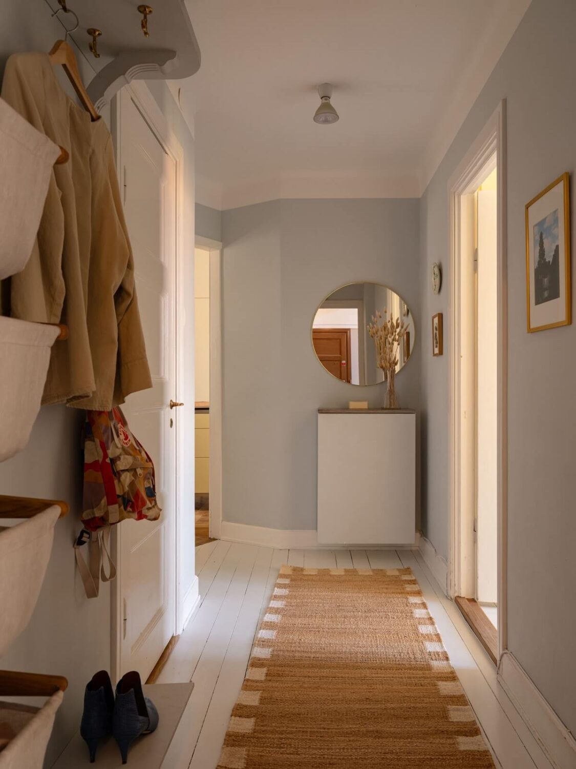A Stockholm Apartment with Bright Green Color Accents 19 hallway with runner and round mirror