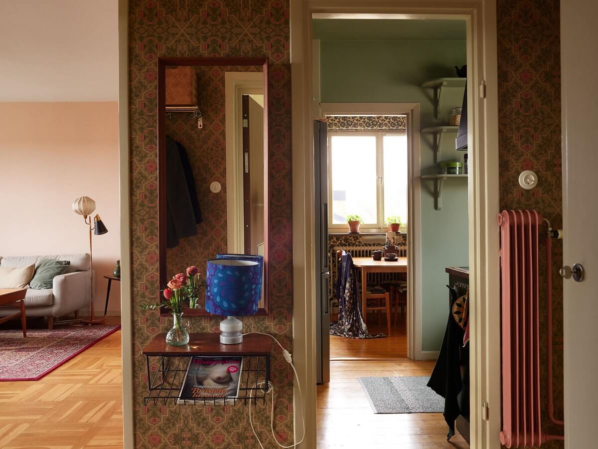 Revisiting a Small Green and Pink Midcentury Apartment 22 hallway with wallpaper and mirror