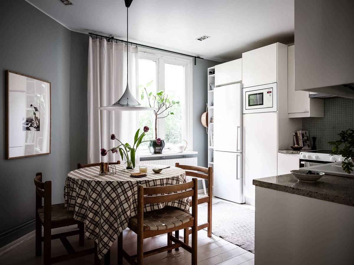 A Scandinavian Apartment with a Rust Red Bedroom 9 kitchen with dark gray wall and round dining table