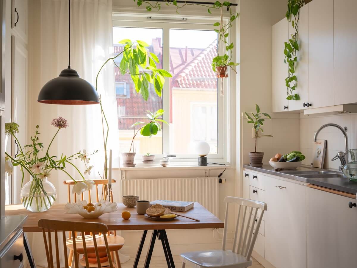 Calm Color Tones in a Light Scandinavian Studio Apartment 9 kitchen with plants and dining table