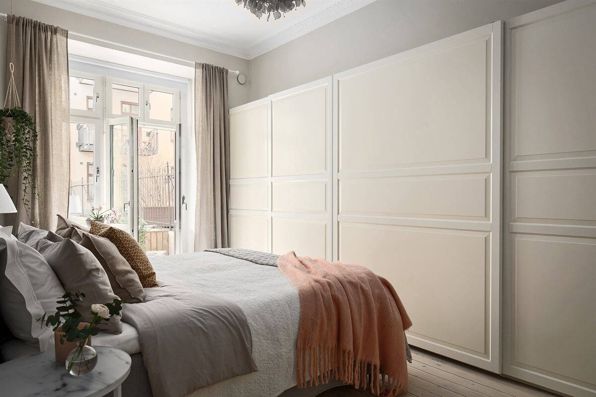 A Swedish Apartment with an Exposed Brick Wall 11 light gray bedroom with wardrobes