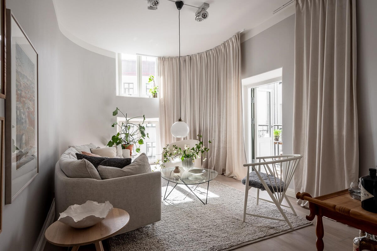 A Stylish Light Gray Swedish Apartment 1 light living room with gray walls and floor to ceiling curtains