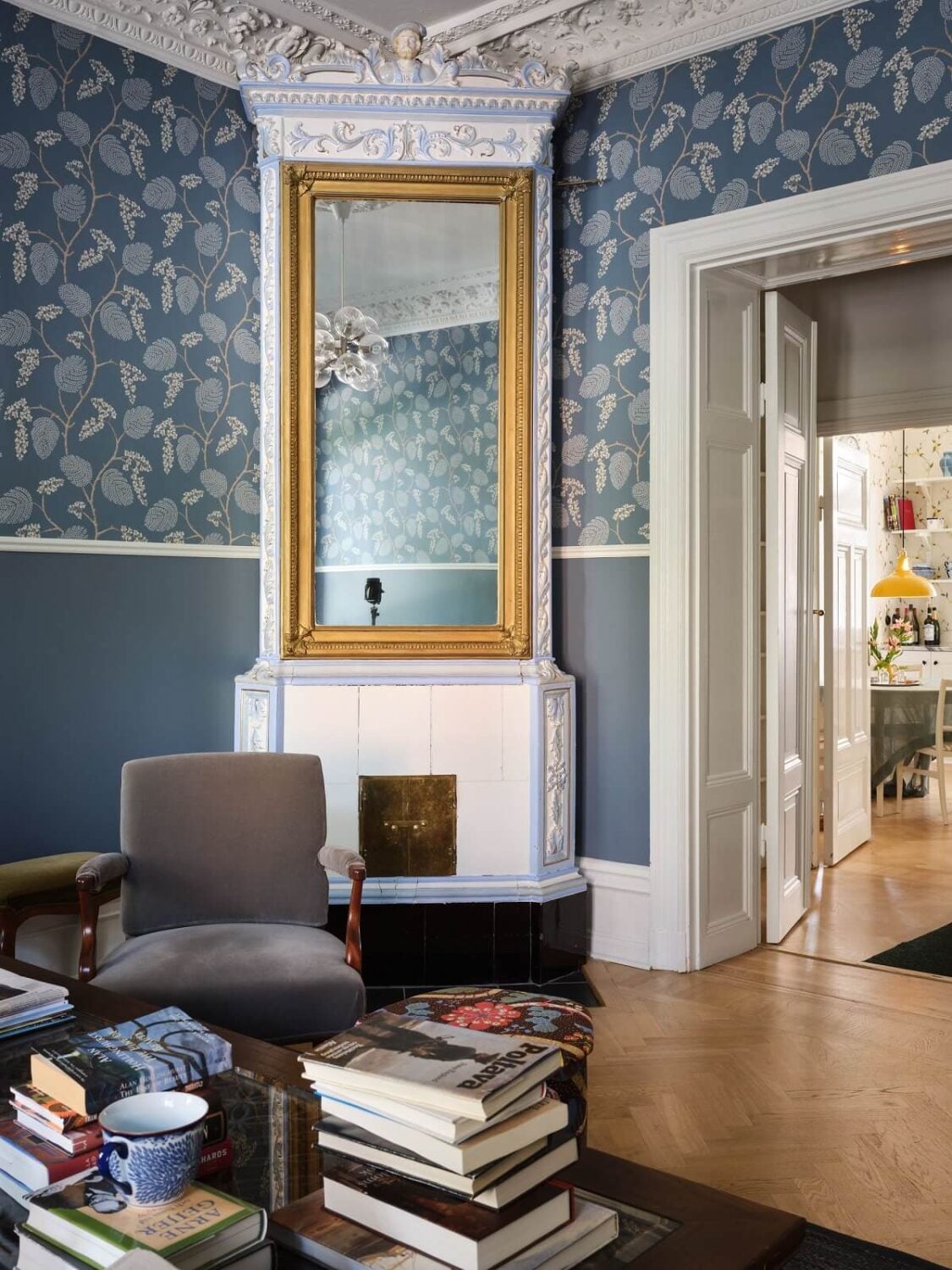 A Classic Stockholm Apartment with Floral Wallpaper 3 living room with blue floral wallpaper and fireplace with gilded mirror nordroom