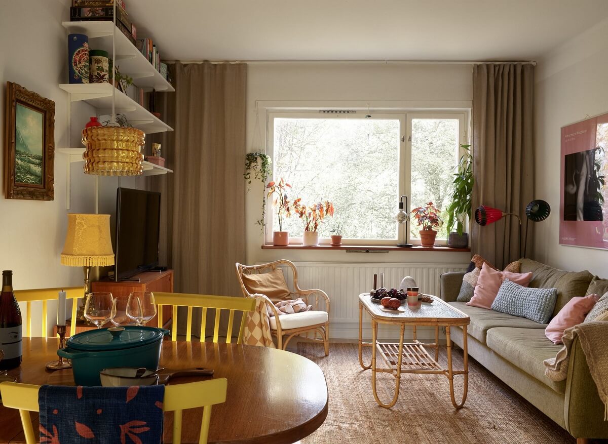 A Swedish Apartment with a Tiny Terracotta Brown Bedroom 1 living room with dining table and shelves