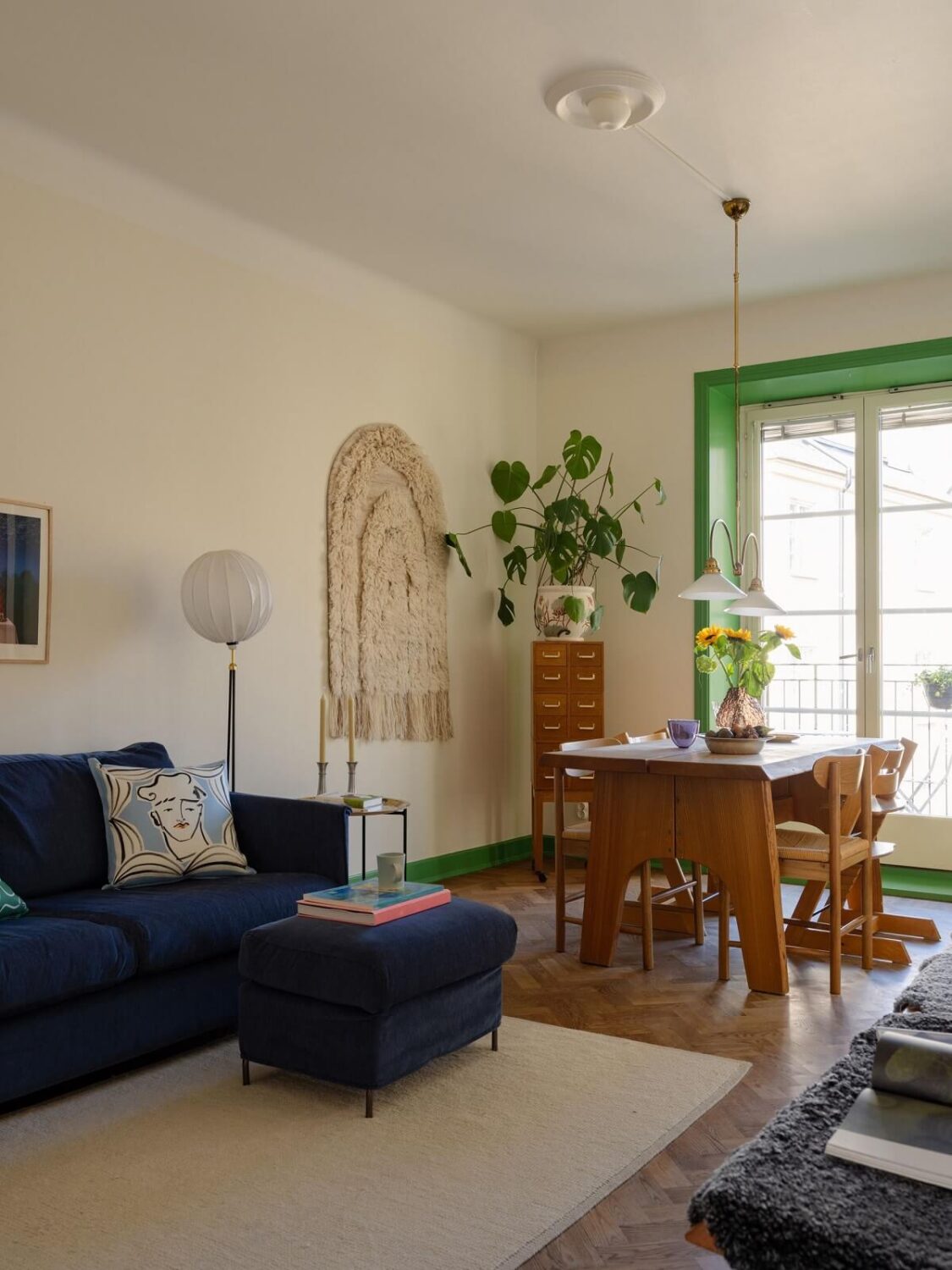 A Stockholm Apartment with Bright Green Color Accents 1 living room with green window trims and blue sofa