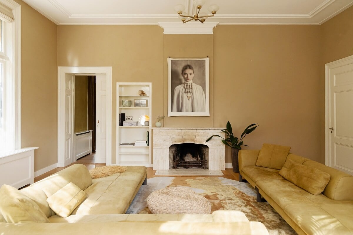 A Warm Atmosphere in a Historic Dutch Villa 13 living room with large sofa and fireplace