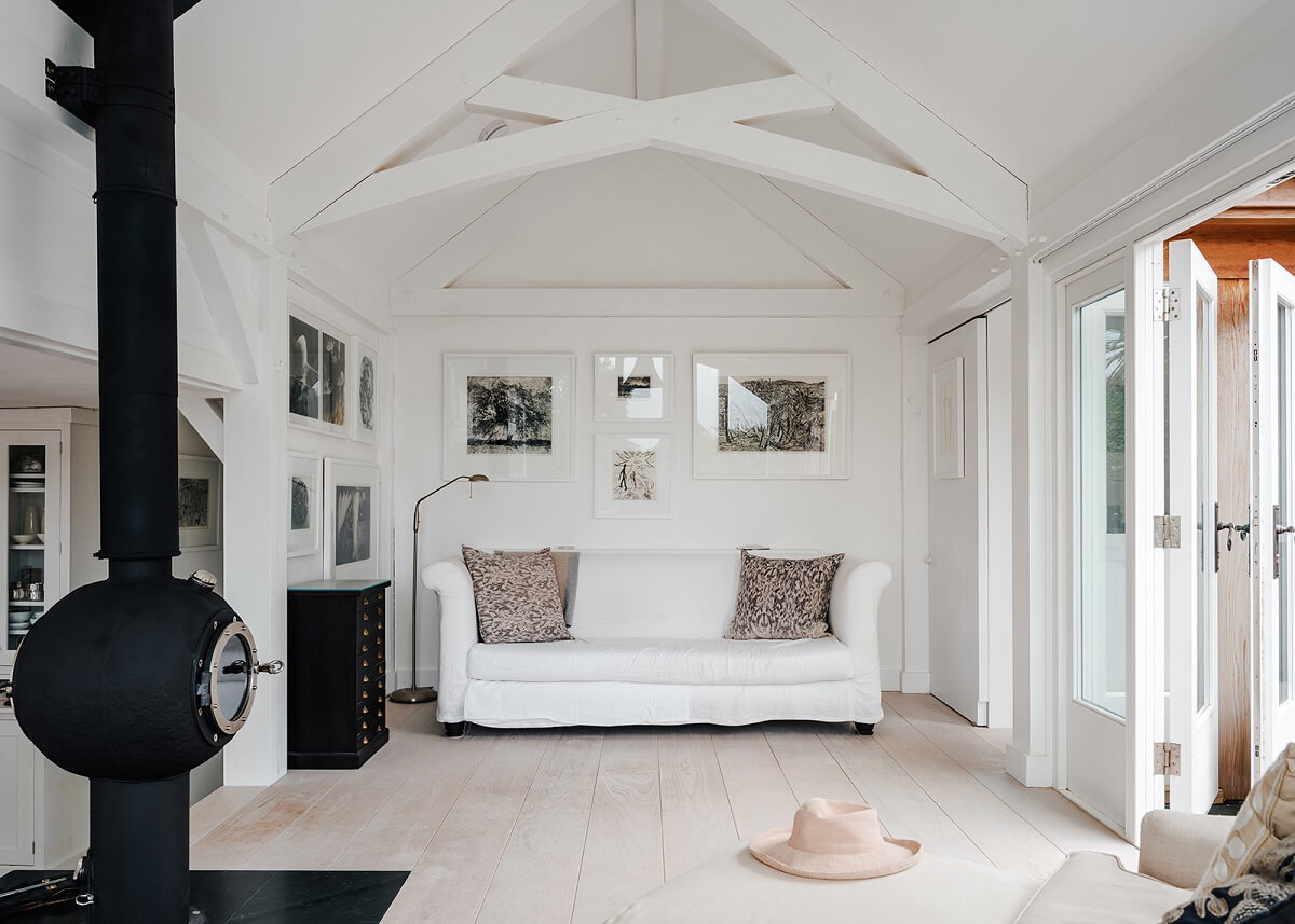 A Coastal White Painter's Home with Reclaimed Features in Cornwall 2 open plan white living space with fireplace
