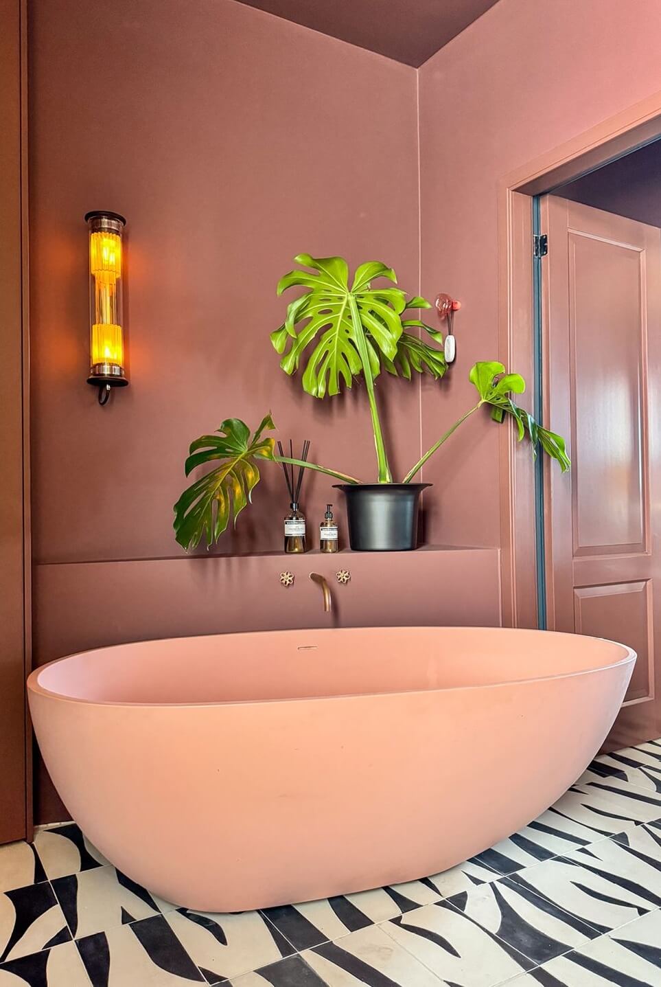 Color and Graphic Design in the Home of a Dutch Interior Stylist 31 pink bath in earthy pink bathroom with graphic black and white tiles